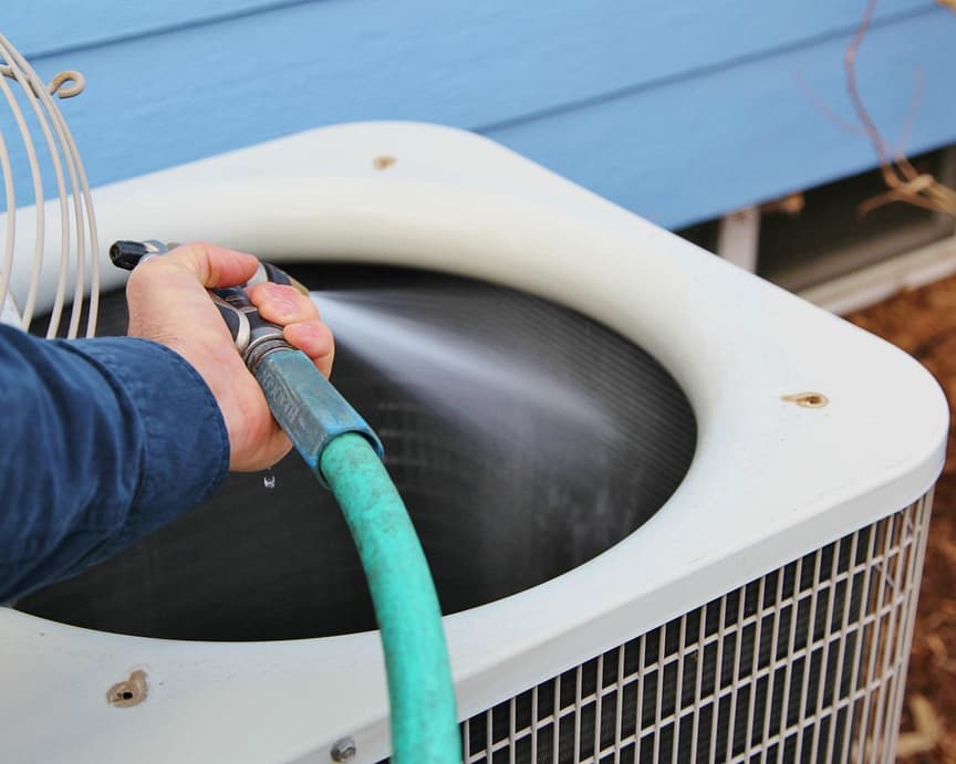 cuci condenser coil AC dengan selang air untuk pendinginan optimal